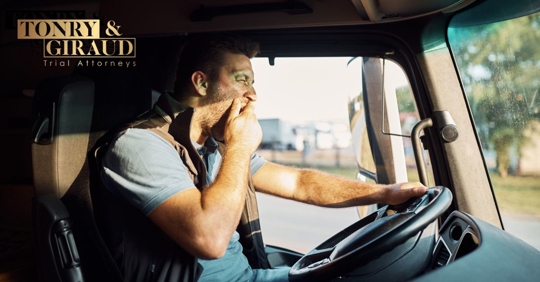 man yawning while driving a truck